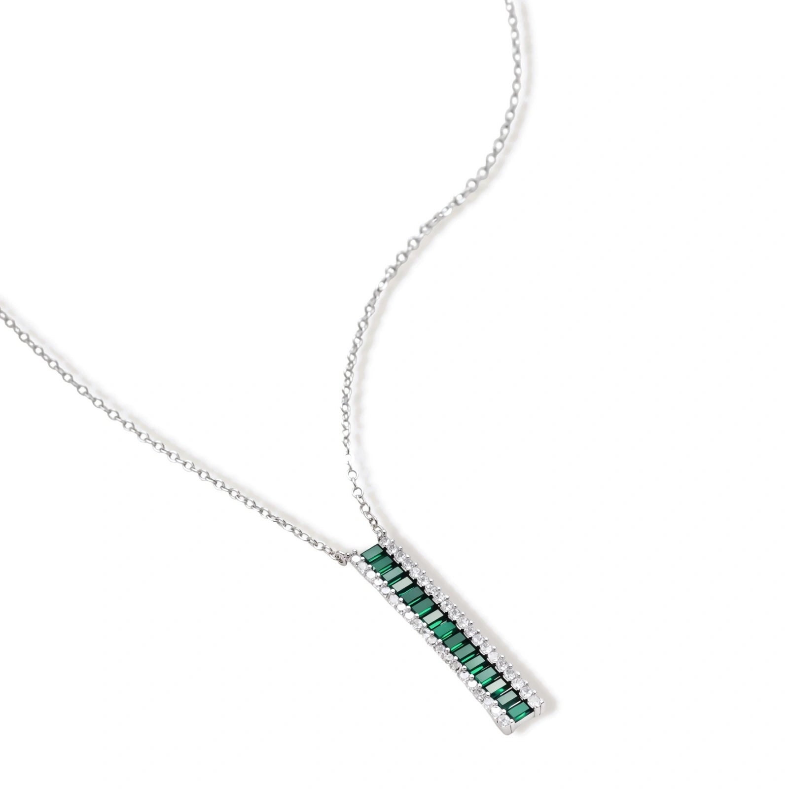 White gold plated jewelry set with emerald green rectangular stones and clear crystals in geometric rows on white background.