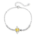 Sterling silver bracelet with yellow moissanite centerpiece in oval setting, crystal chain, and star charm on white background.