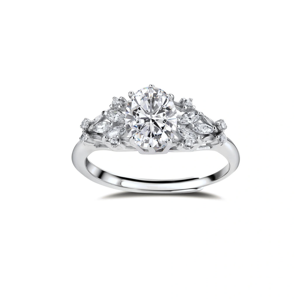 Sterling silver ring with oval moissanite center stone surrounded by smaller accent stones in ornate setting