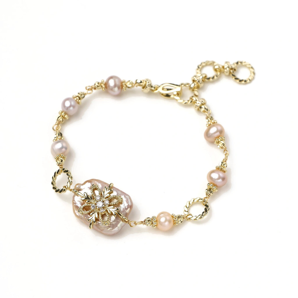 Gold-plated bracelet with pink baroque pearl centerpiece, floral connector, and freshwater pearls
