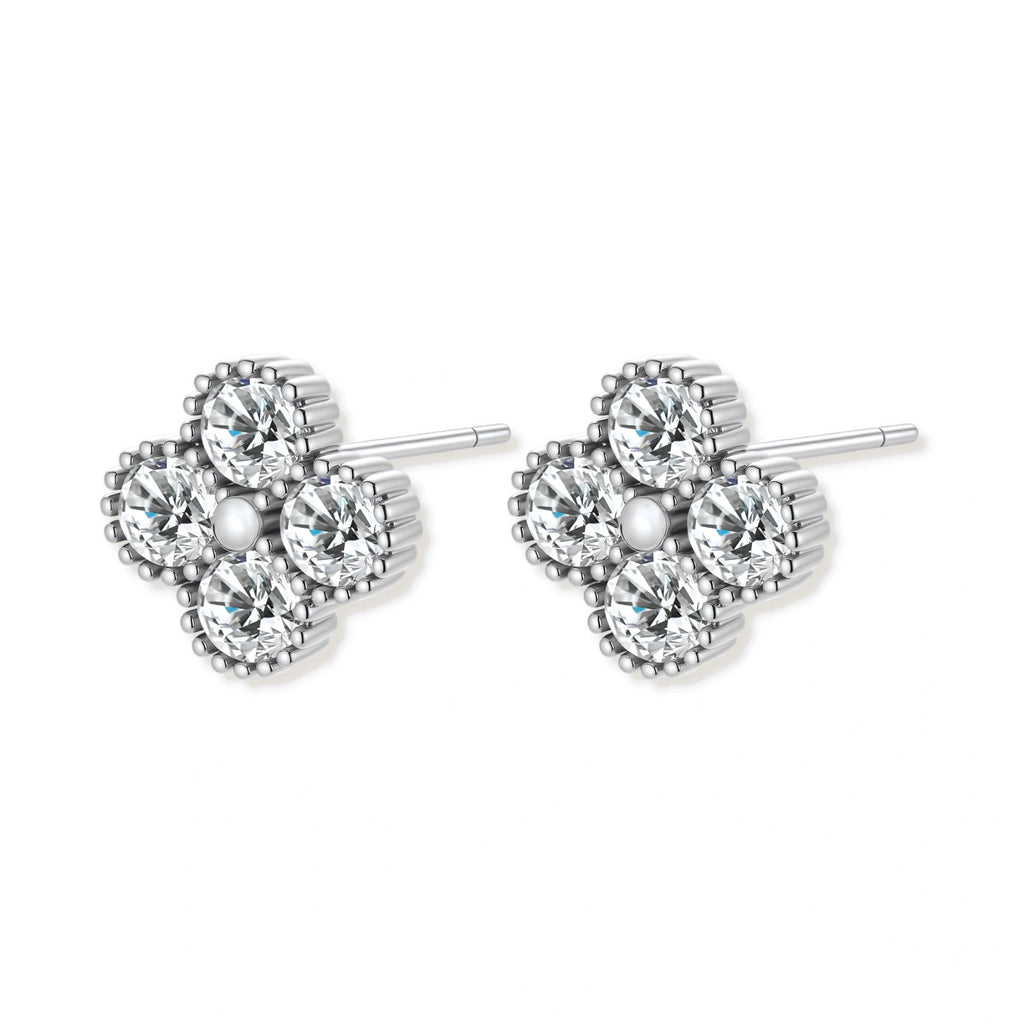 Dainty sterling silver quatrefoil stud earrings with four brilliant moissanite stones and center accent on white background.
