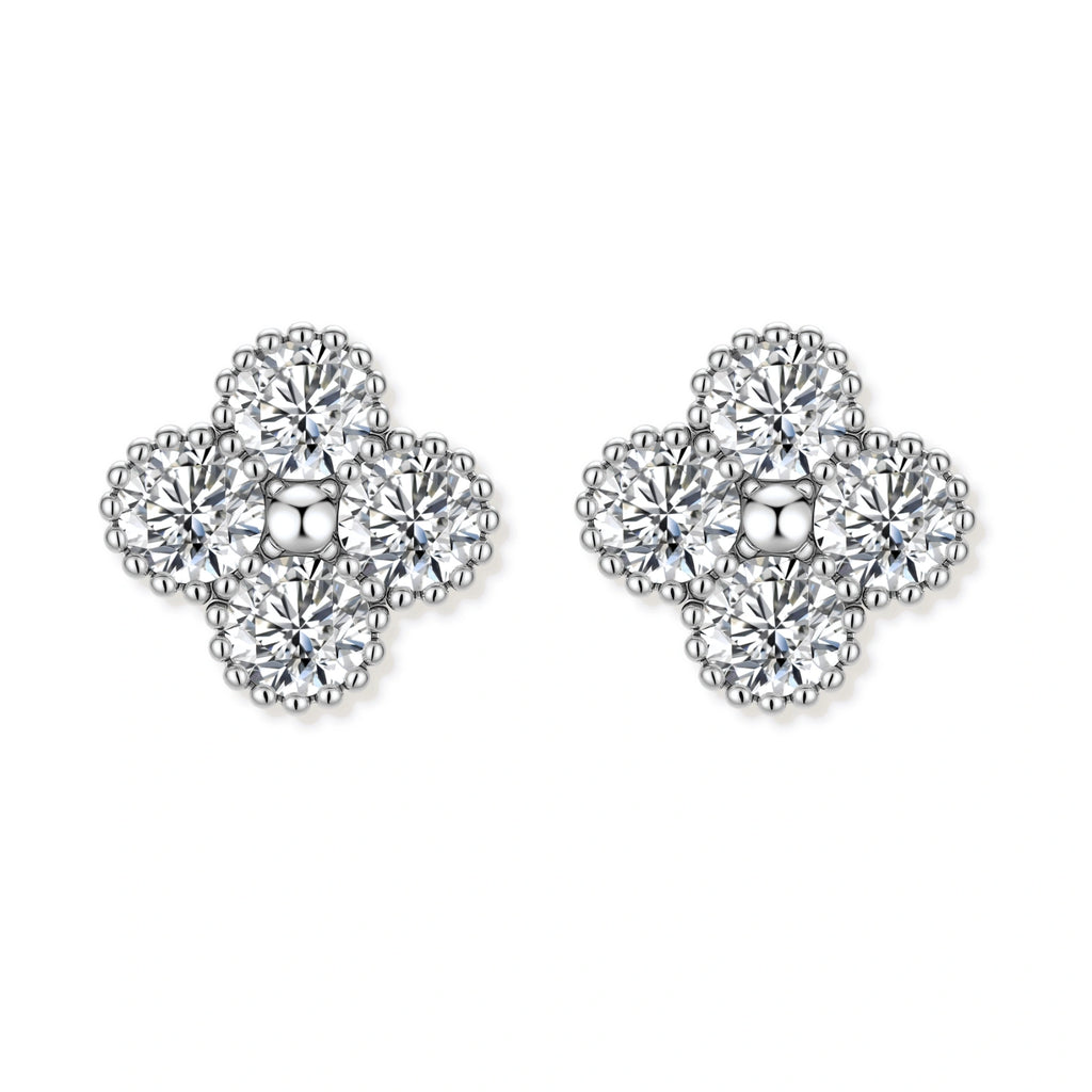 Dainty sterling silver quatrefoil stud earrings with four brilliant moissanite stones and center accent on white background.