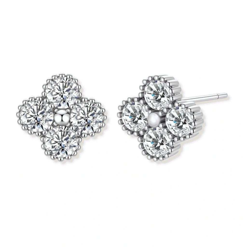 Dainty sterling silver quatrefoil stud earrings with four brilliant moissanite stones and center accent on white background.