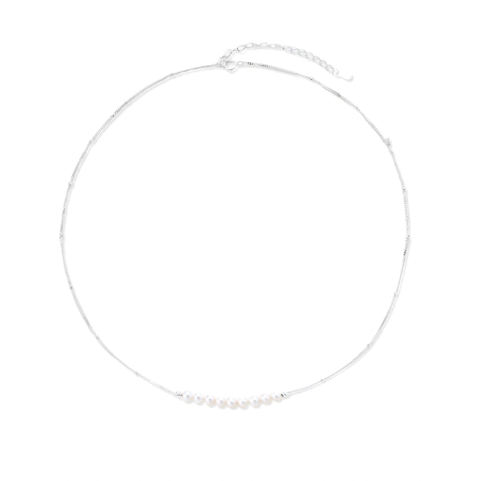 Delicate sterling silver chain necklace with small freshwater pearls arranged in a curved smile arc on cream background.