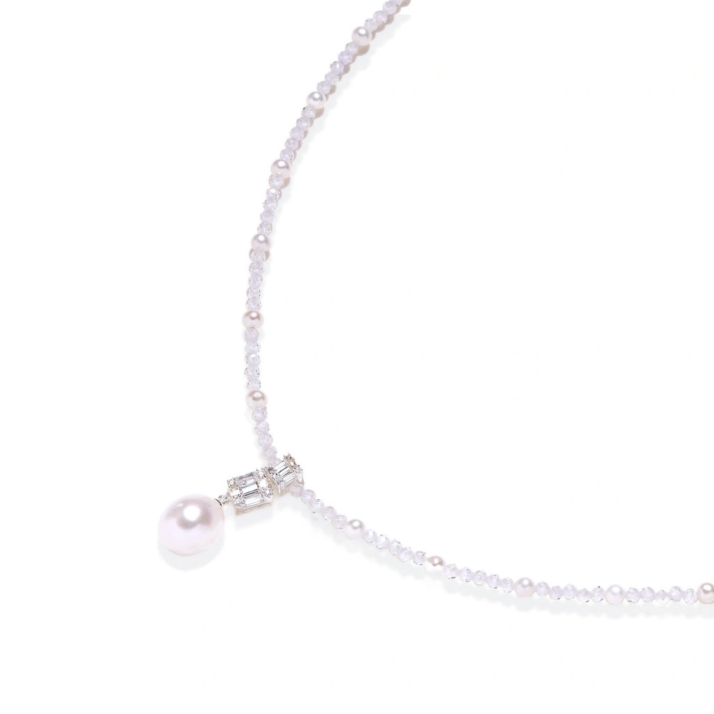Dainty necklace with lavender crystal beads, freshwater pearls, geometric pendant, and large pearl drop on white background.