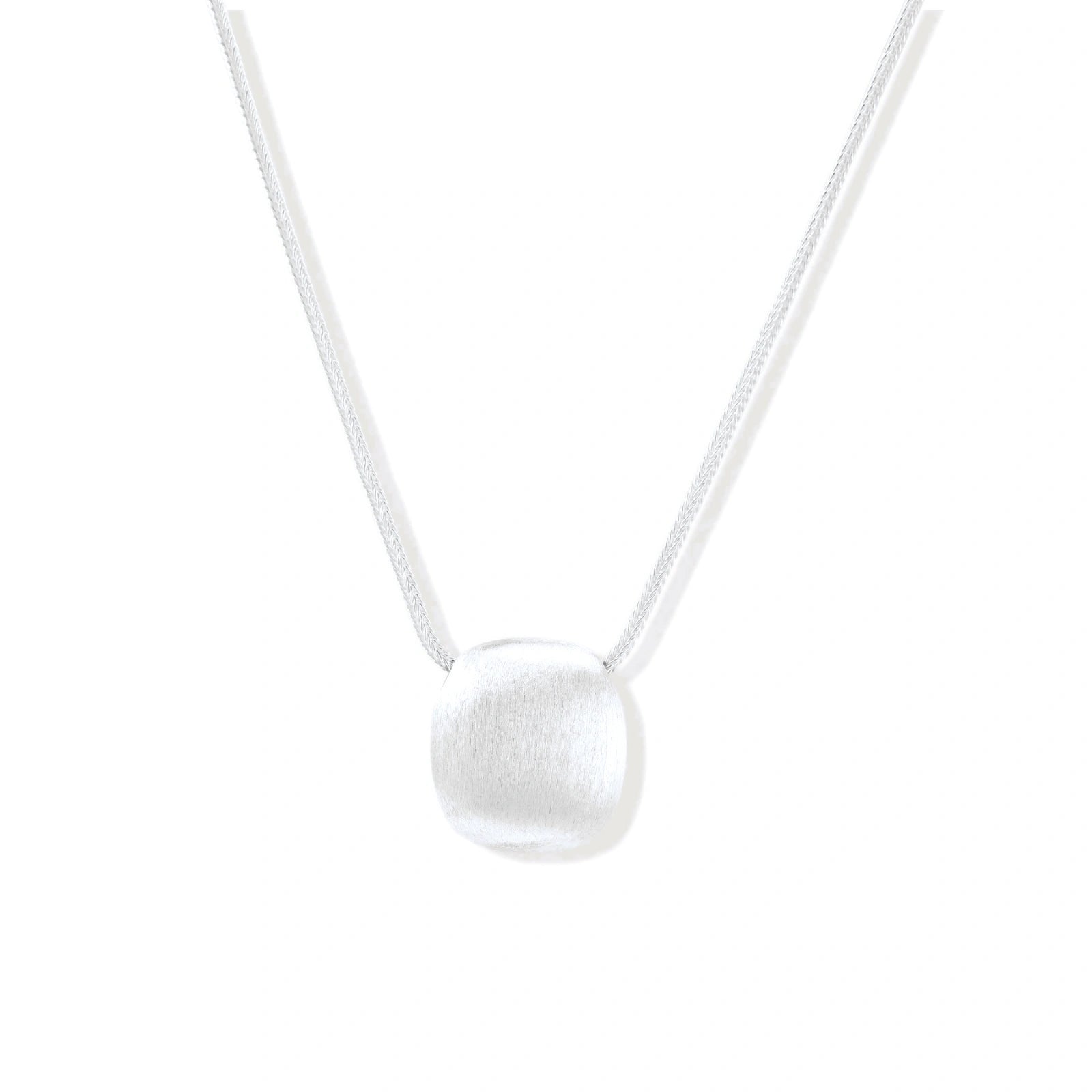 Minimalist brushed sterling silver dome pendant on delicate chain against cream background, showing matte textured finish