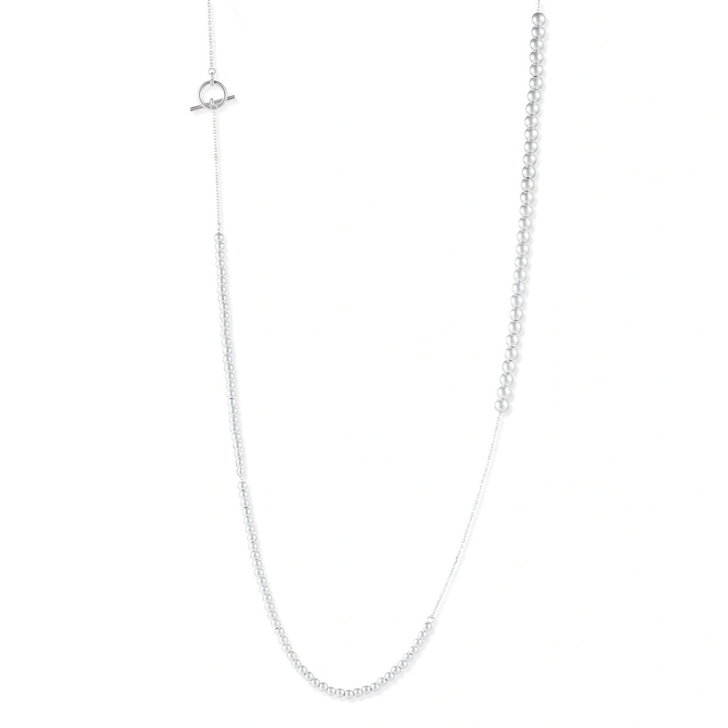 Long sterling silver beaded necklace with graduated sphere design, toggle clasp, and delicate chain extension on white background