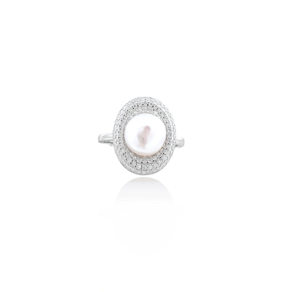 Silver ring with lustrous white pearl center surrounded by sparkling crystal halo on light background.