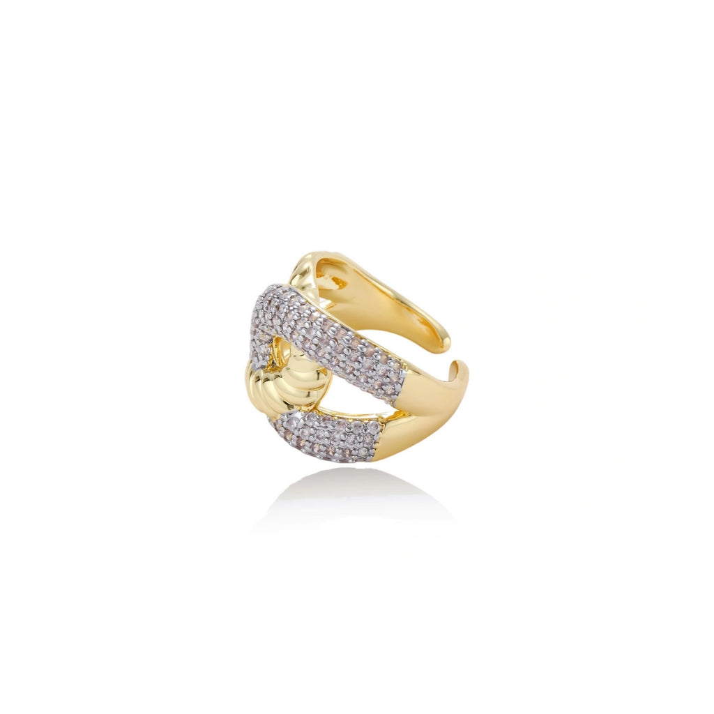 Chunky gold-plated chain-link ring with curved segments and sparkling zirconia crystals on neutral background