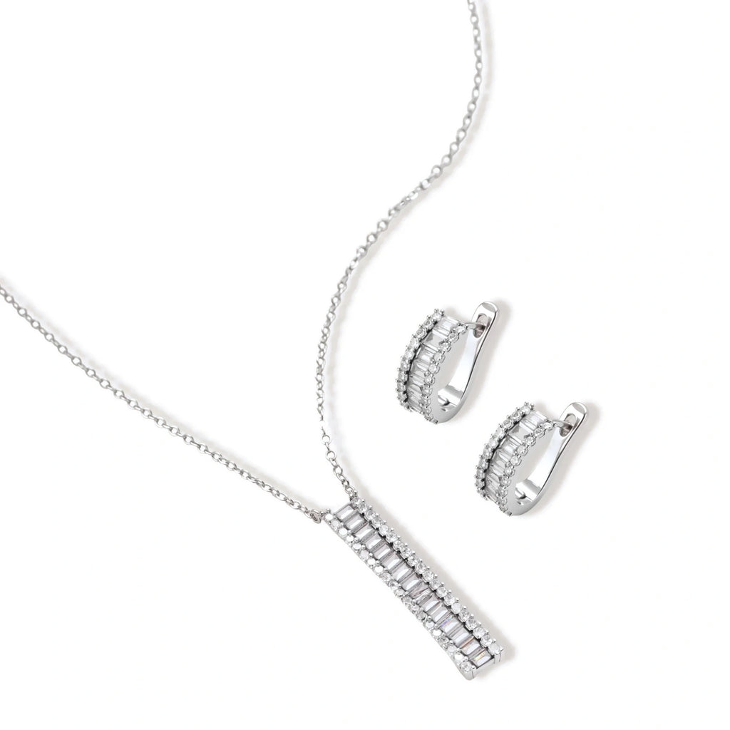 White gold plated necklace with vertical cubic zirconia pendant and matching hoop earrings on neutral background