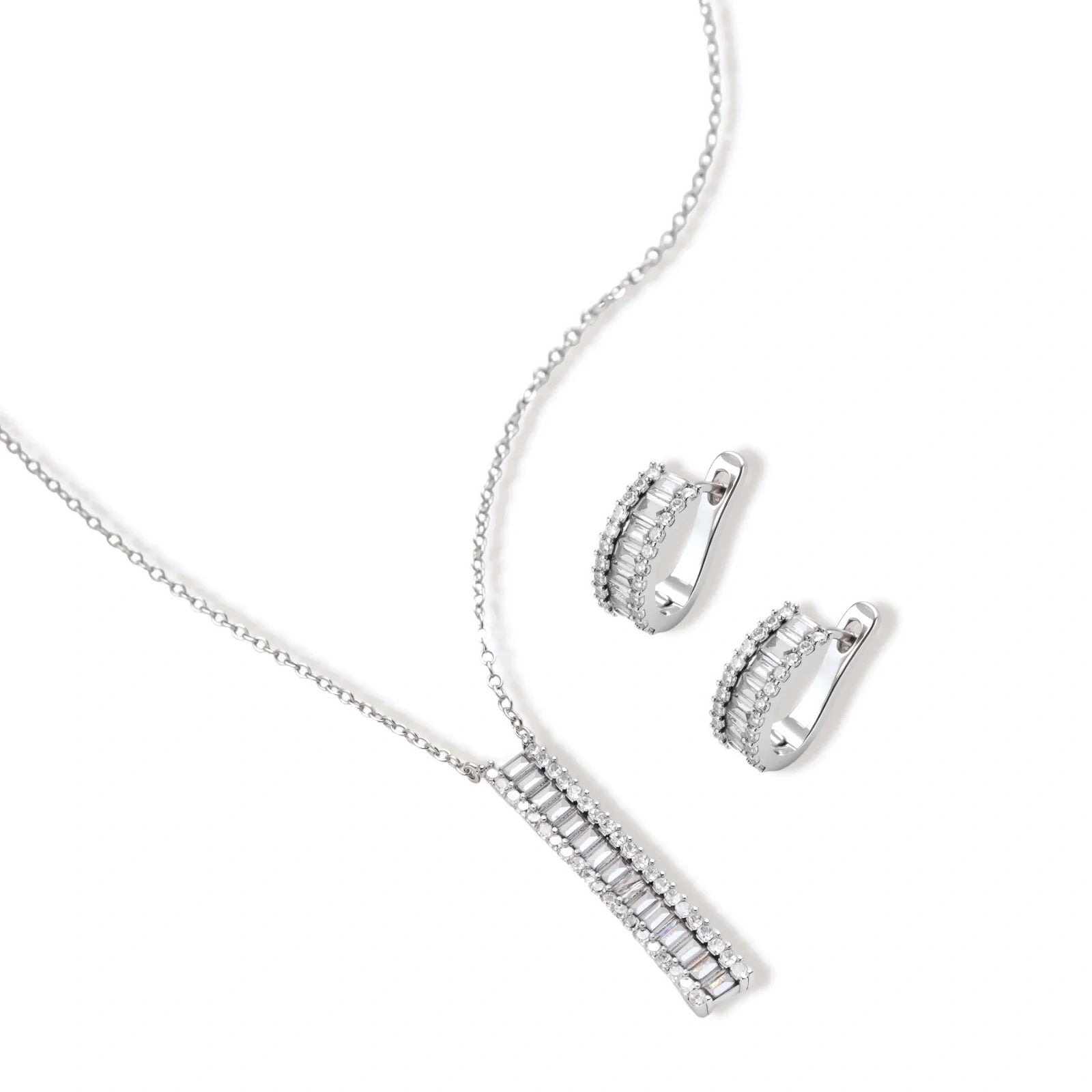 White gold plated necklace with vertical cubic zirconia pendant and matching hoop earrings on neutral background